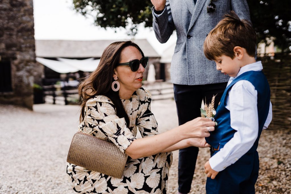 Mother adjusts her son's boutonniere.
