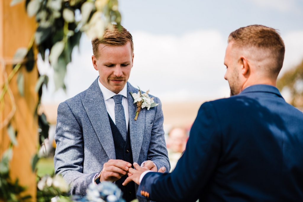 Groom places ring on groom's finger.