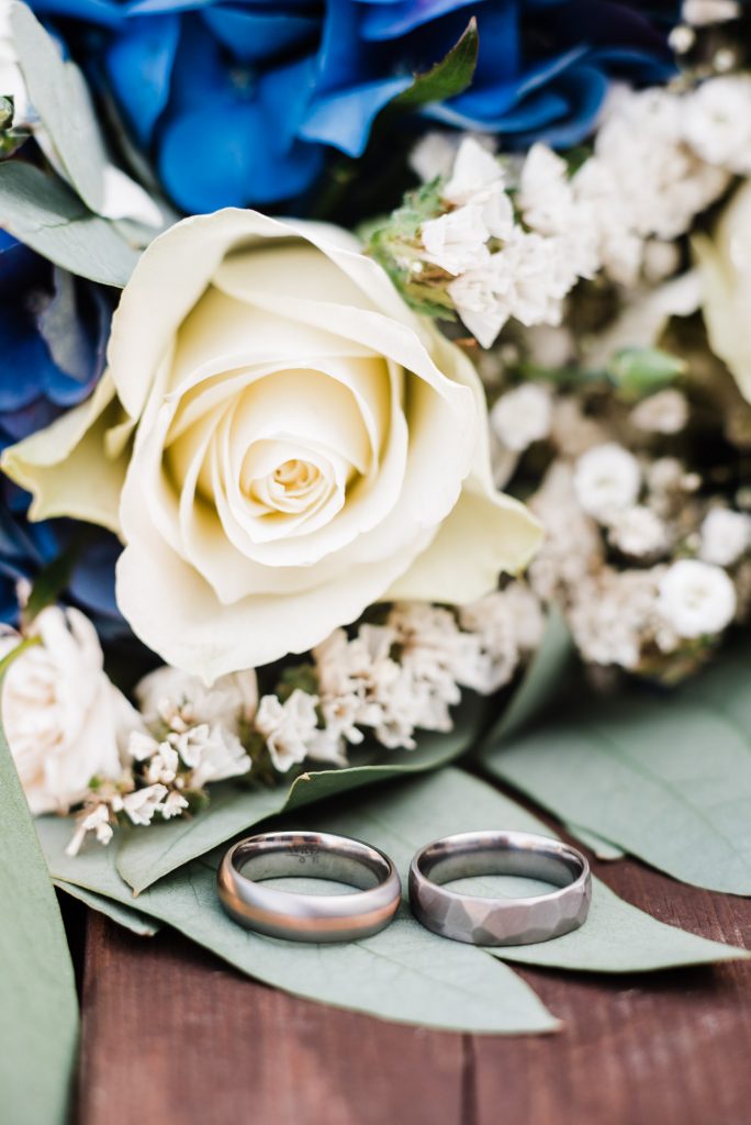 Close up wedding rings and wedding flowers.