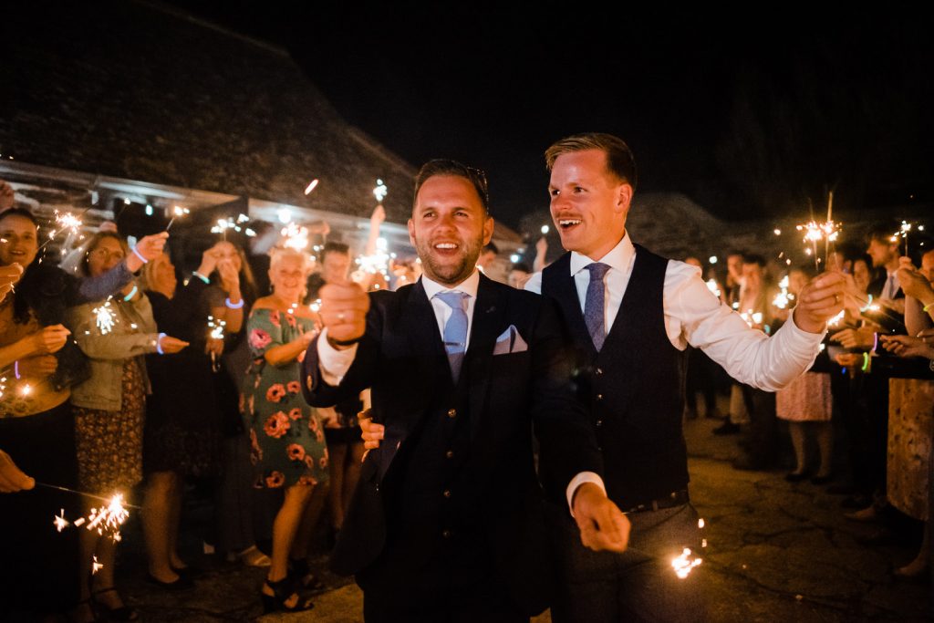 Grooms and guests with sparklers.