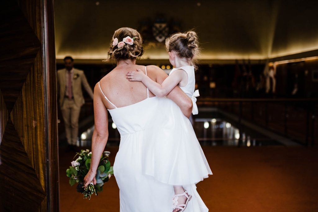 Bride carries daughter out of ceremony room at Plymouth Council House.