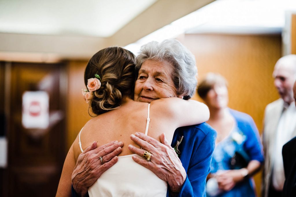Grandmother embraces her granddaughter following wedding ceremony.