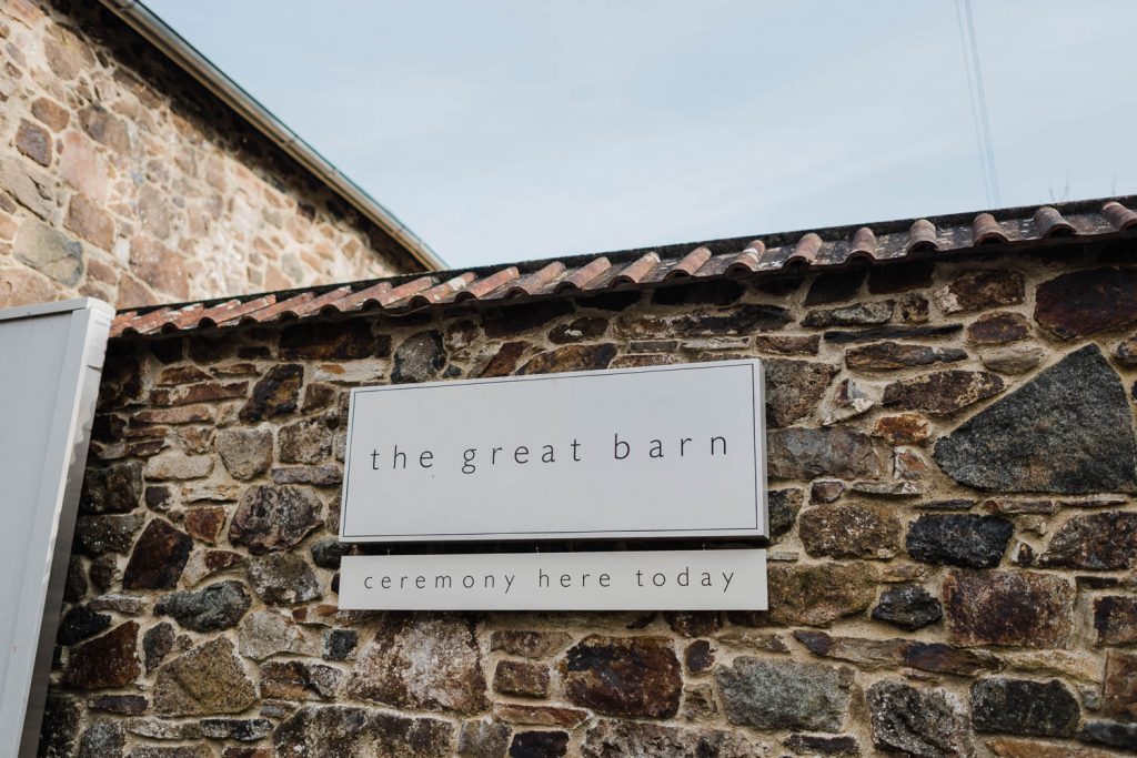 The Great Barn Devon sign on stone wall.
