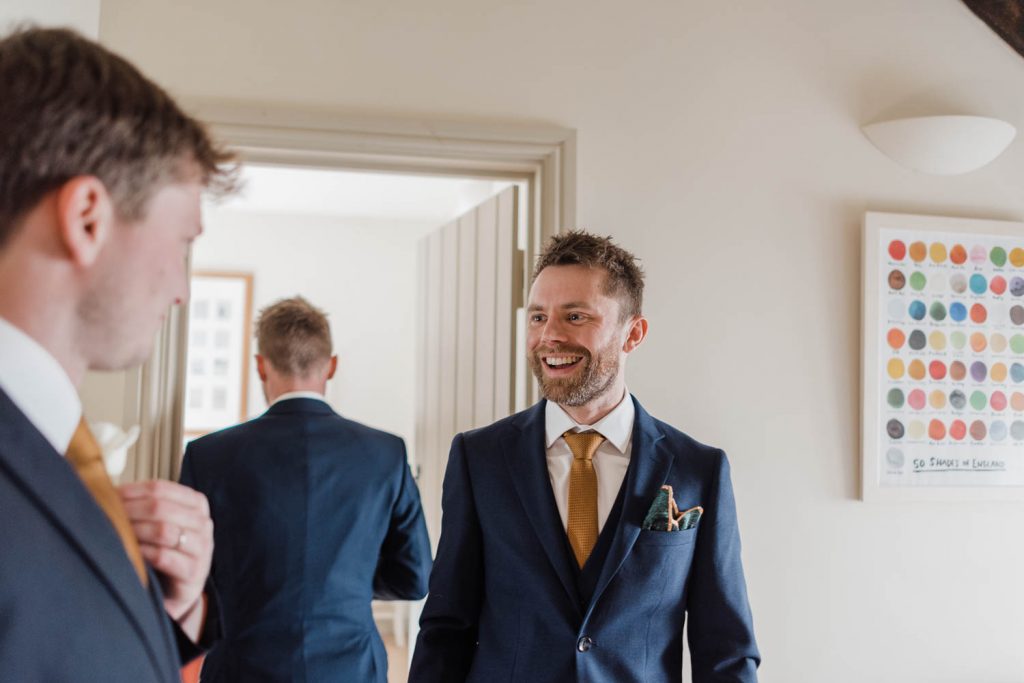 Groom laughs with one of his groomsmen.