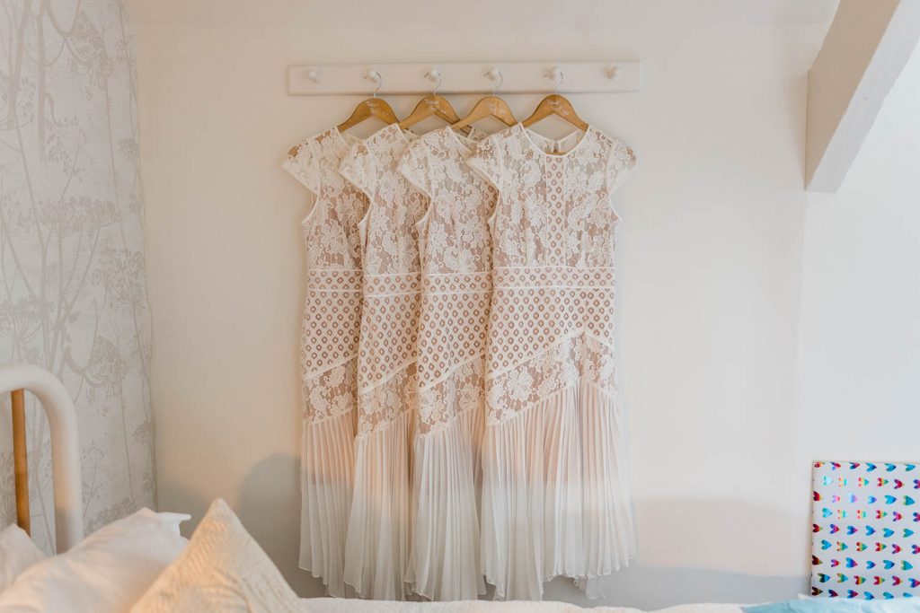 The bridesmaids dresses hang in the bedroom.