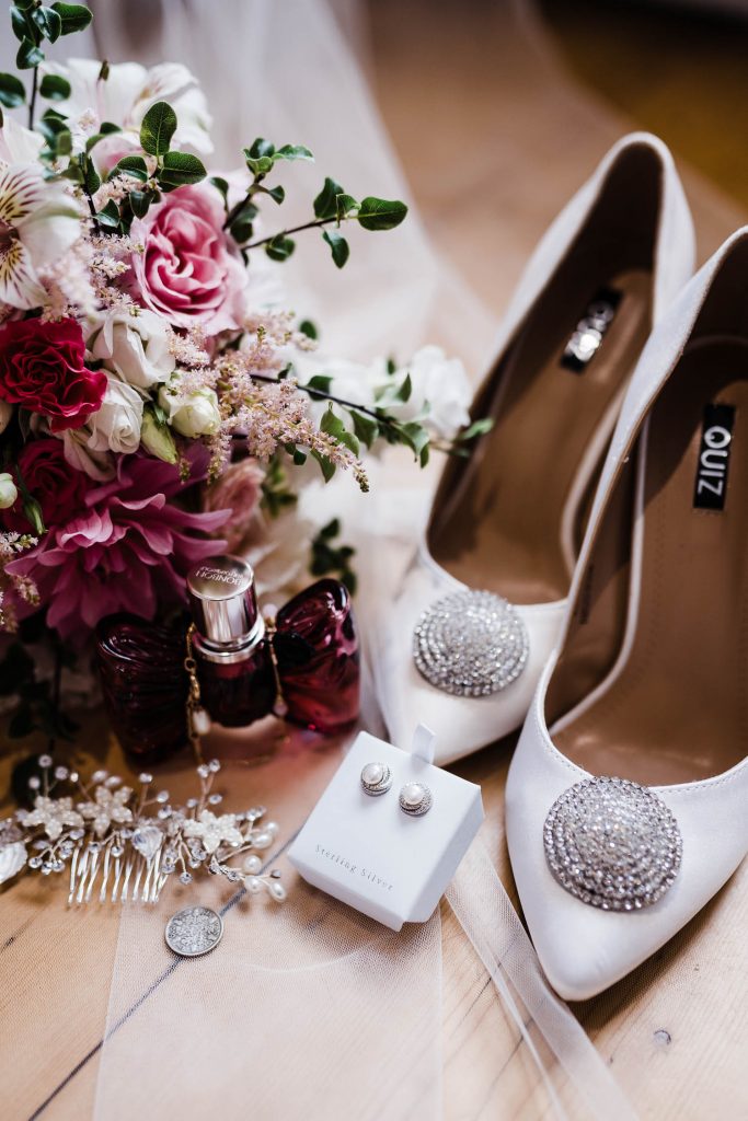 The bride's shoes, perfume, jewellery and flowers.
