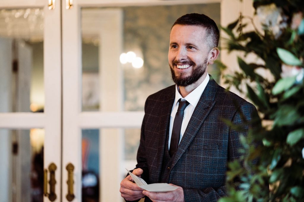 Guest smiles as he finishes a reading during the wedding ceremony.