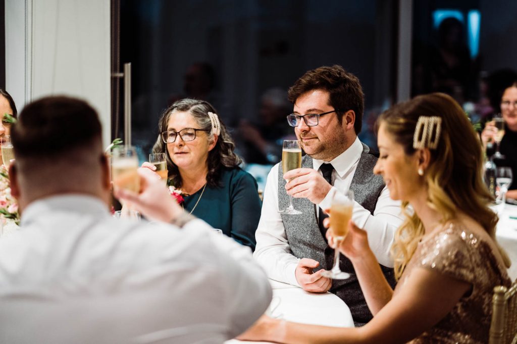 bridal party toast their glasses during speeches.