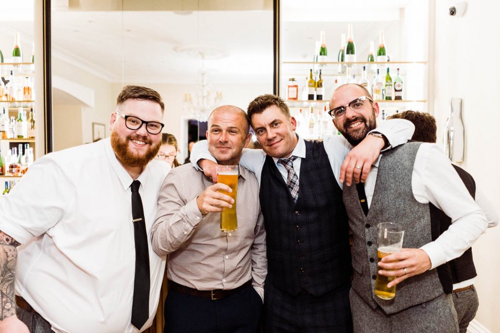 the groom and friends pictured at the bar.
