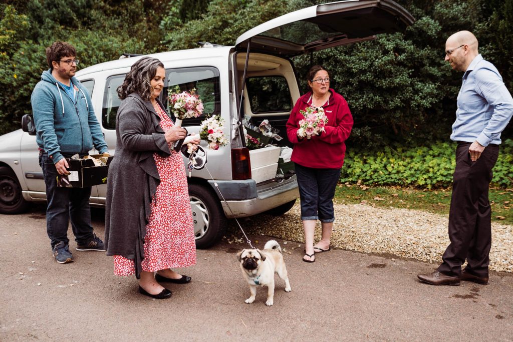 The bride's aunt unloads wedding flowers from mini-van.