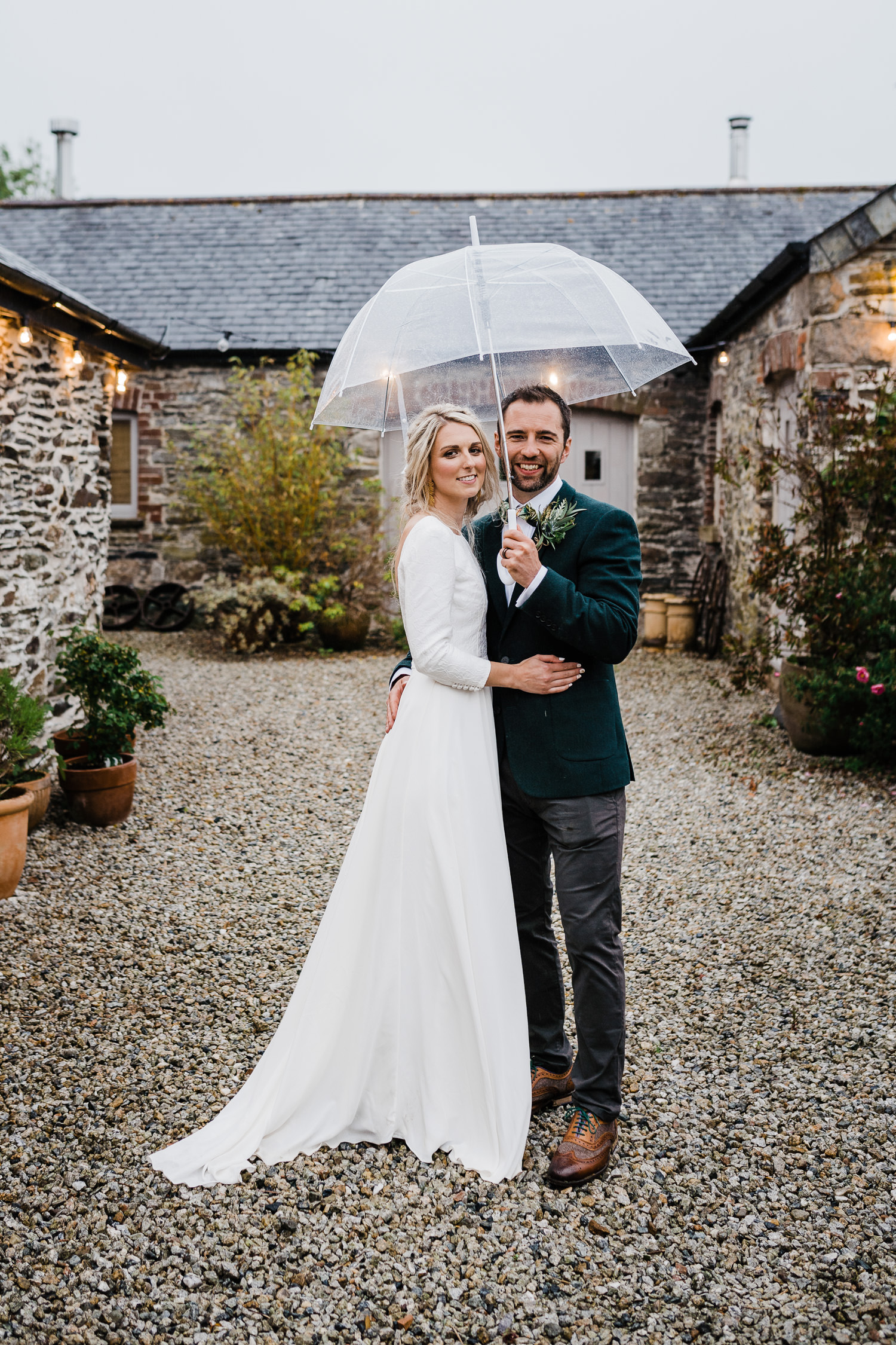 Bride and Groom under clear umbrella.