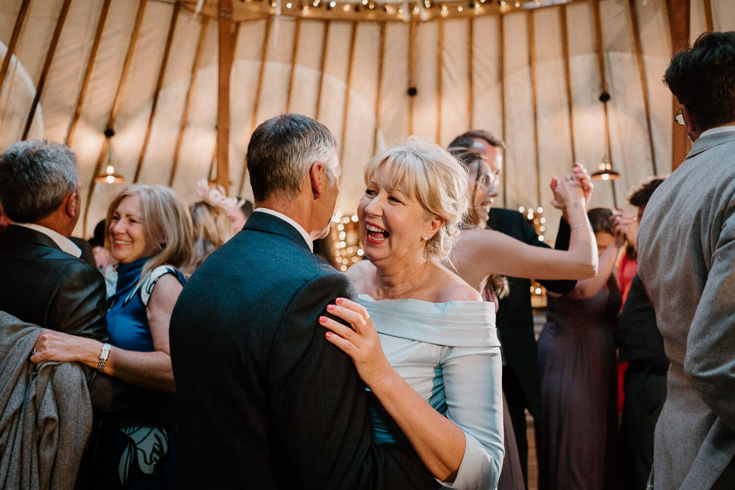 Groom's parents dance inside the Big Yurt at Kingston Estate, Devon.