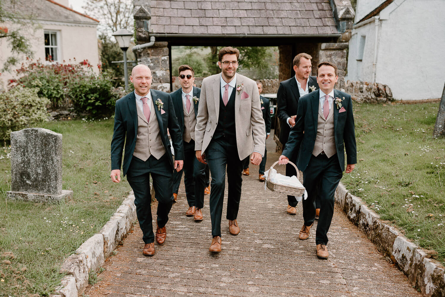 Groom and groomsmen walk towards the church in Ipplepen, Devon.