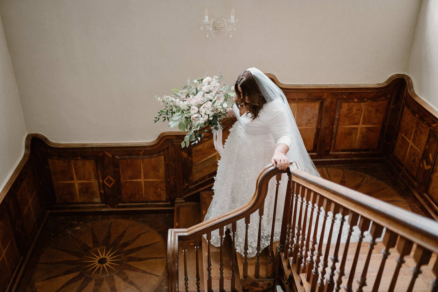 Bride descends the ornate staircase at Kingston Estate.