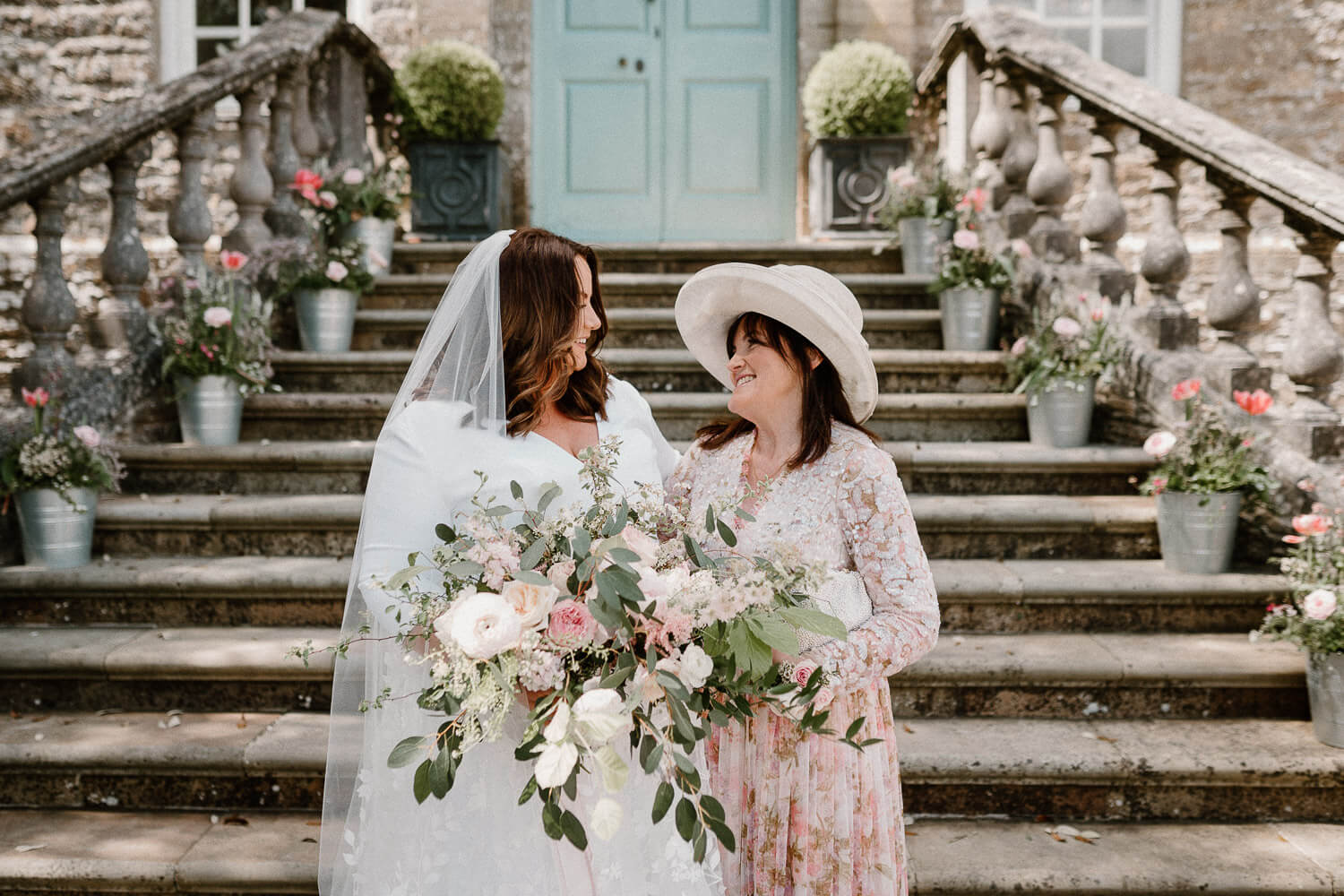 A candid moment between shared between a bride and her mother on the steps at Kingston Estate.