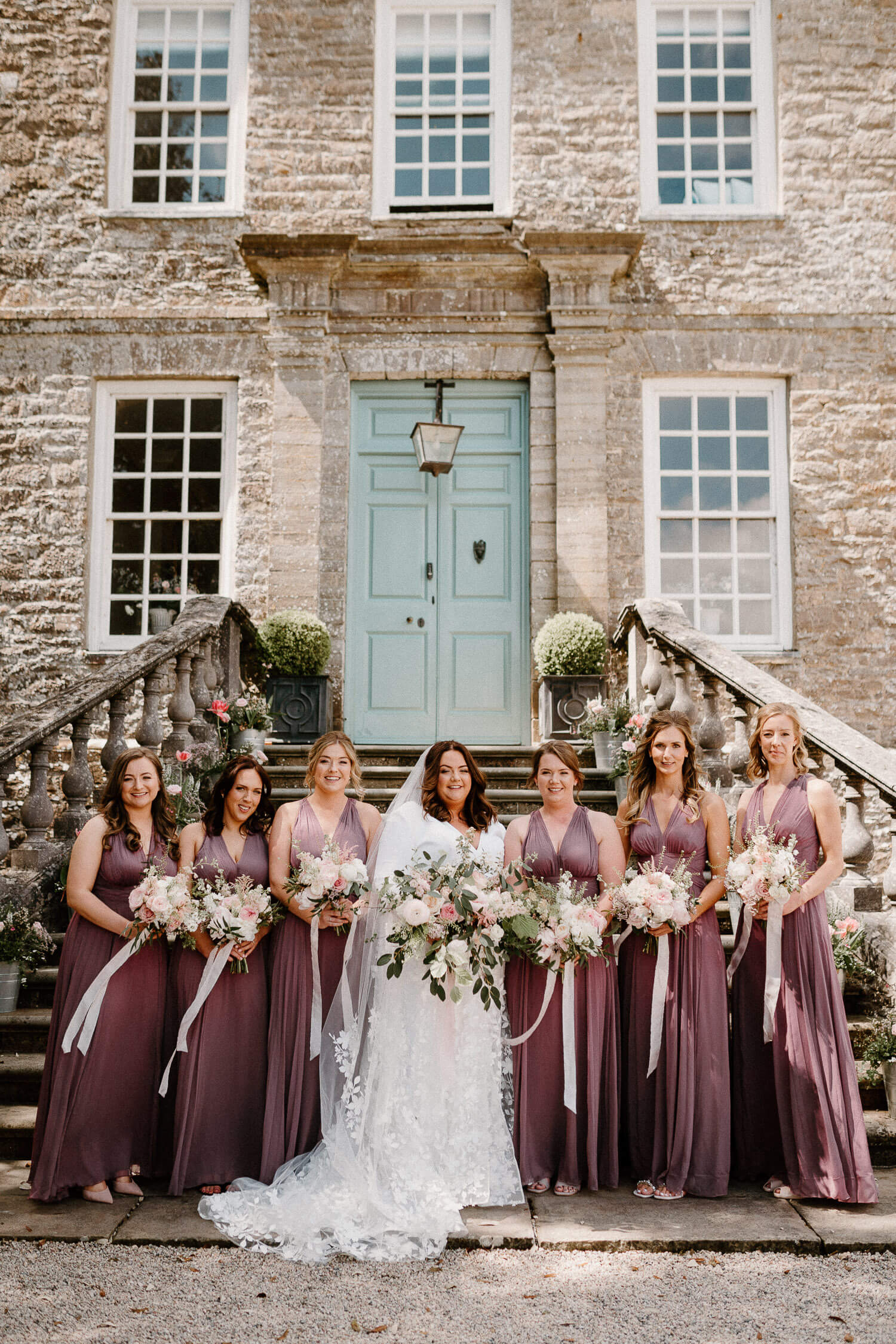 Bride and bridesmaids pose for photo on steps at Kingston Estate.