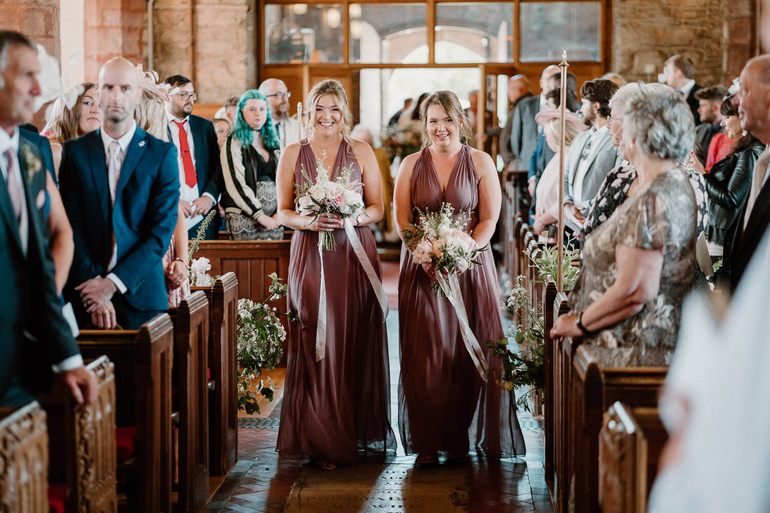 Bridesmaids walk down the aisle at St Andrew's Church in Ipplepen, Devon.