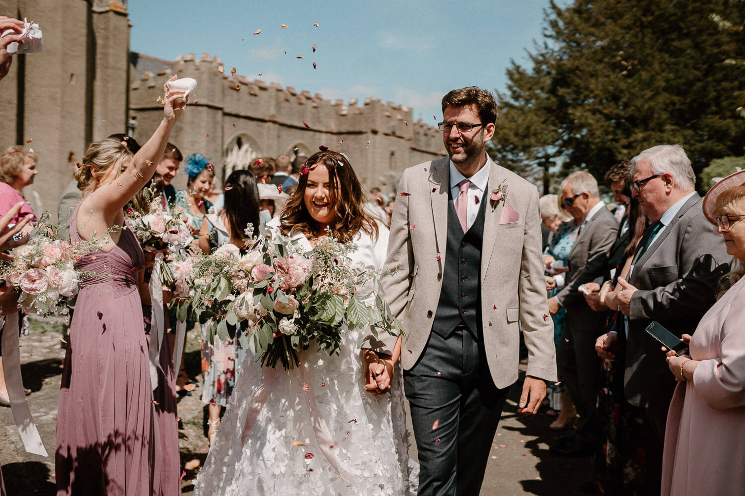 Bride and groom are showered with confetti outside St Andrew's Church, Ipplepen.