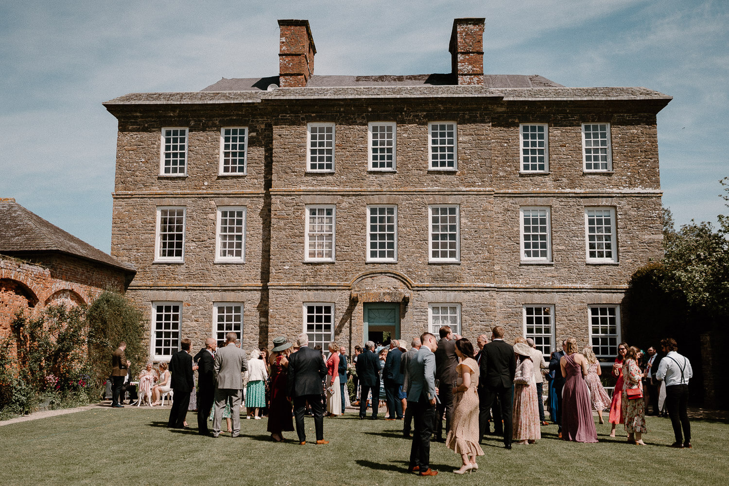 Wide angle view of Kingston Estate country house from the walled garden where guests mingle.